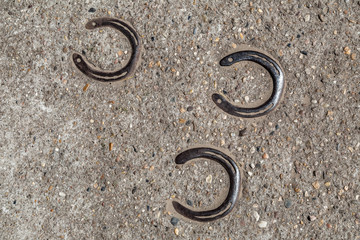 drei Hufeisen in Beton gegossen