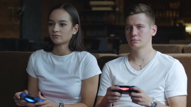 Young couple playing video game at home.