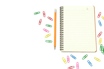 Top view workspace Notebook,Multi-colored paper clip, Notepad with yellow pencil placed On the office desk Has space for text Creative office style concept