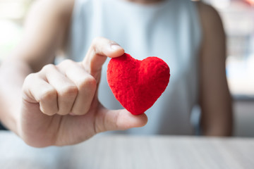 woman hand holding  Red heart shape in office. Love, Happy Valentines day holiday and healthy...