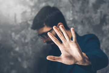man hand stop sign on dark background