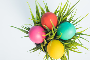 Top view of Easter eggs clean in grass on white wooden background