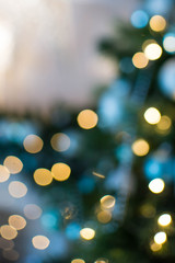 Out of focus texture background of Christmas tree with ornaments and Christmas lights.
