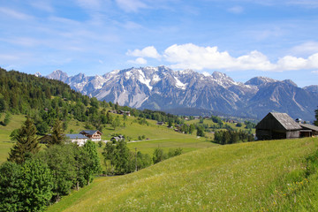Panorama landscape and mountain meadows in Styria with view to the Dachstein mountains. View from Schladming, Austria