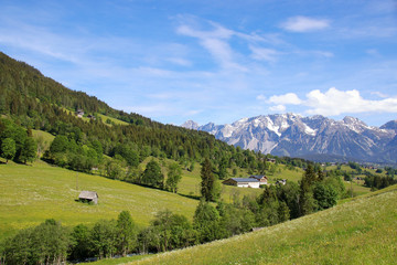Panorama landscape and mountain meadows in Styria with view to the Dachstein mountains. View from Schladming, Austria