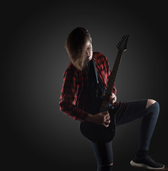 handsome musician playing guitar on the black background