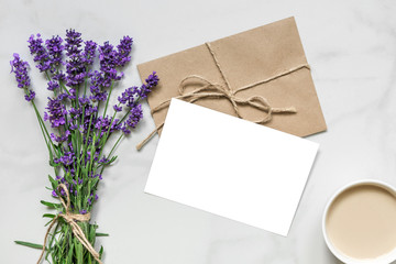 mock up blank greeting card and envelope with lavender flowers and cup of cappuccino with copy space. top view