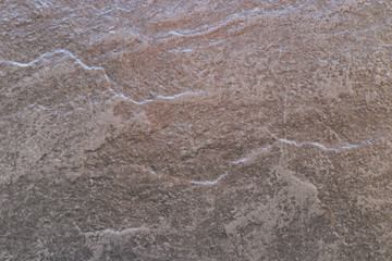 The texture of the surface of a brown facing stone with irregularities. Brown background with space for text or image.