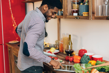 Black man searching recipe on digital tablet in kitchen