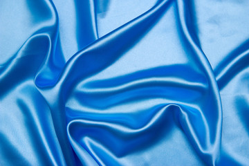Background from a blue satin fabric with picturesque folds