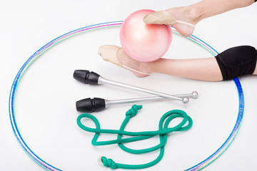 Accessories for rhythmic gymnastics ball, clubs, ribbon, rope lie on the floor. Black background