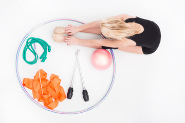 Accessories for rhythmic gymnastics ball, clubs, ribbon, rope lie on the floor. Black background