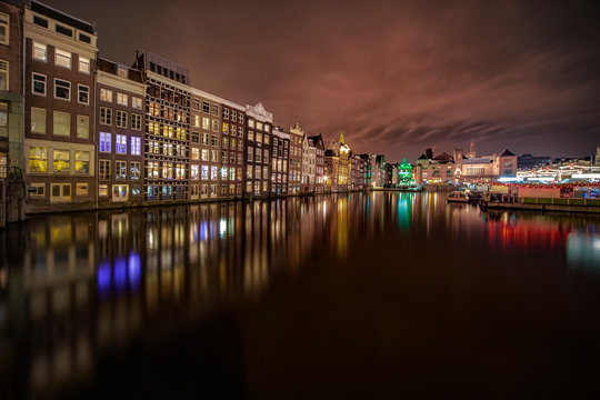 Iconic Amsterdam view with its canals and illuminated houses in front the train station, Netherlands © Ankor light