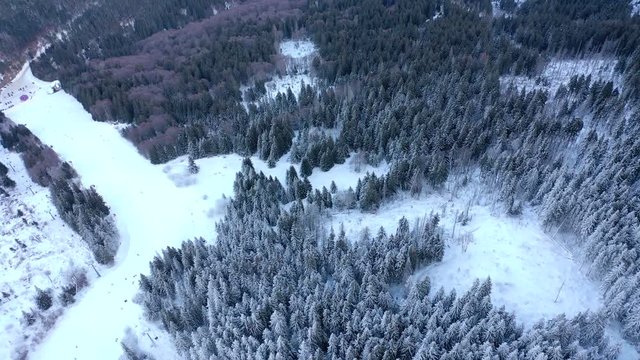 Aerial view skiers and snowboarders on ski lift on snow mountain in ski resort. Ski elevator for people transportation in mountain resort drone view. Winter sport on ski resort.