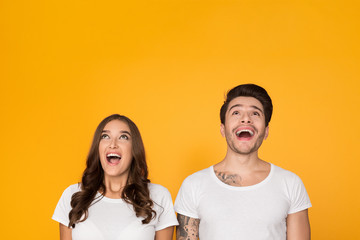 Young man and woman looking upward in excitement