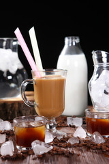 Glass of mulled wine with coffee and milk. Drinking tubes in the glass. The concept of still life coffee and ice on a wooden background.