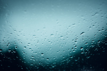 Details of water drops on a car window in the moody winter mountain landscape. Harz Mountains National Park in Germany