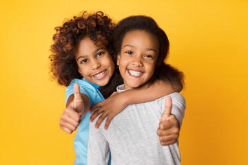 Adorable african-american girls posing on studio background