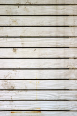 Vertical image of white colored wooden plank wall of an old building