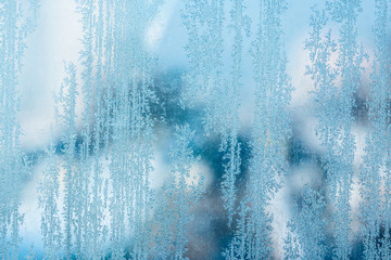 vertical thin ice patterns on a frozen winter glass close-up bright day nature concept