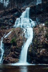 Mountain waterfall with blurry long exposure water with moody dark winter environment. Harz Mountains National Park in Germany