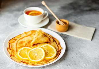 Food, dessert, pastries, pancake, pie. Tasty beautiful pancakes with banana and honey on a concrete background
