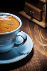 espresso in white coffee cup and mill very close up view