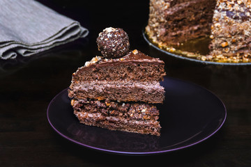 slice chocolate nut cake with candy balls. dark key