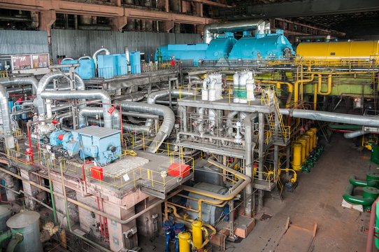 machine hall of thermal power station inside interior with pipes and turbines