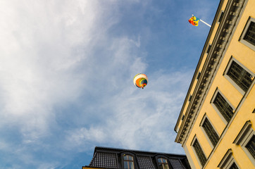 Fototapeta na wymiar Colorful hot air balloon in blue sky over buildings, Stockholm, Sweden