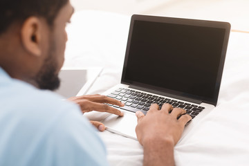 African-american man browsing work opportunities on laptop