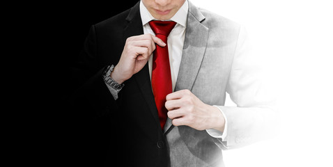 Fototapeta Businessman in blank and white suit tying red necktie. Good and devil, true identity, and balance concept obraz