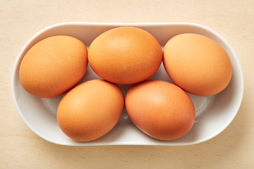 Whole raw egg on wooden table. 
