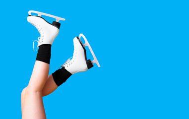 Ice skating, skater, female feet in skates shoes isolated on blue background. Winter time. Girl, winter sports, copy space, panoramic view