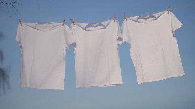 T-shirts hanging on the clothesline against blue sky