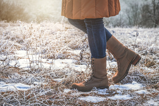Woman wearing leather hiking boots in winter frozen nature