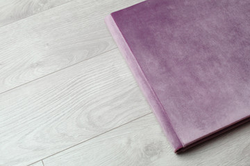 photo book of fabric.
Photo book on a light background.

Photo album with a hard cover on a wooden background.
Bright  photo album.