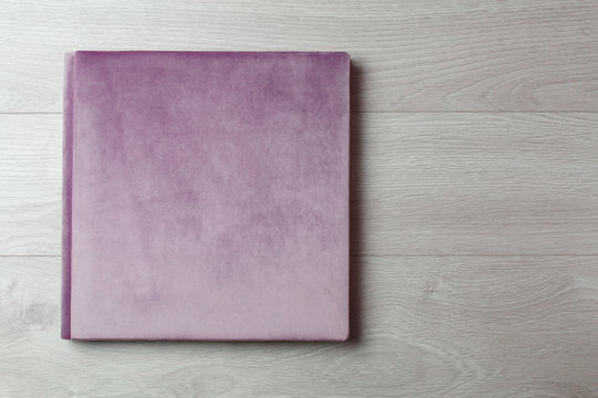 photobook  family photo book on  light background close up portrait. wedding photo album with fabric hard cover on  wooden background with copy space for text. Bright  photoalbum.