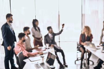 blurred image. business people are having a chat in the office with panorama window