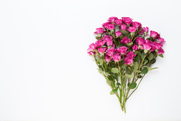 Flowers composition. Frame made of red rose on white wooden background. Flat lay, top view, copy space.