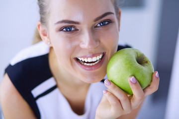 Close up portrait of healthy smiling woman with green apple.