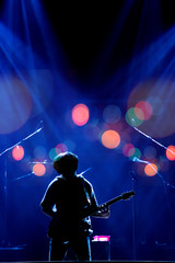 Asian Musician playing the guitar on black background with spot light, bokeh and lens flare,...
