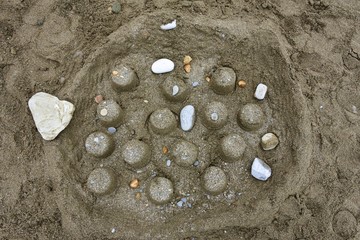 Children's creativity on the beach. Sand pyramids. Stonehenge by the hands of children.