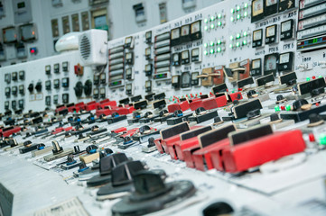 white control board with many switches and lights in operator room of thermal power station