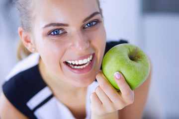 Close up portrait of healthy smiling woman with green apple.