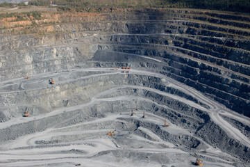 Aerial view industrial of opencast mining quarry with lots of machinery at work