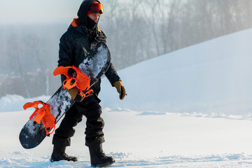 man with snowy snowboard is going up the hill. copy space.man spending holiday at ski resort