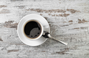 Coffee cup and spoon on wood table background. Flat lay.