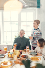 awesome blond woman , her husband and daughter are talking compliment somebody.