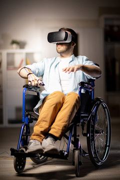 Casual young man in vr headset sitting in wheelchair and experiencing virtual adventure at leisure
